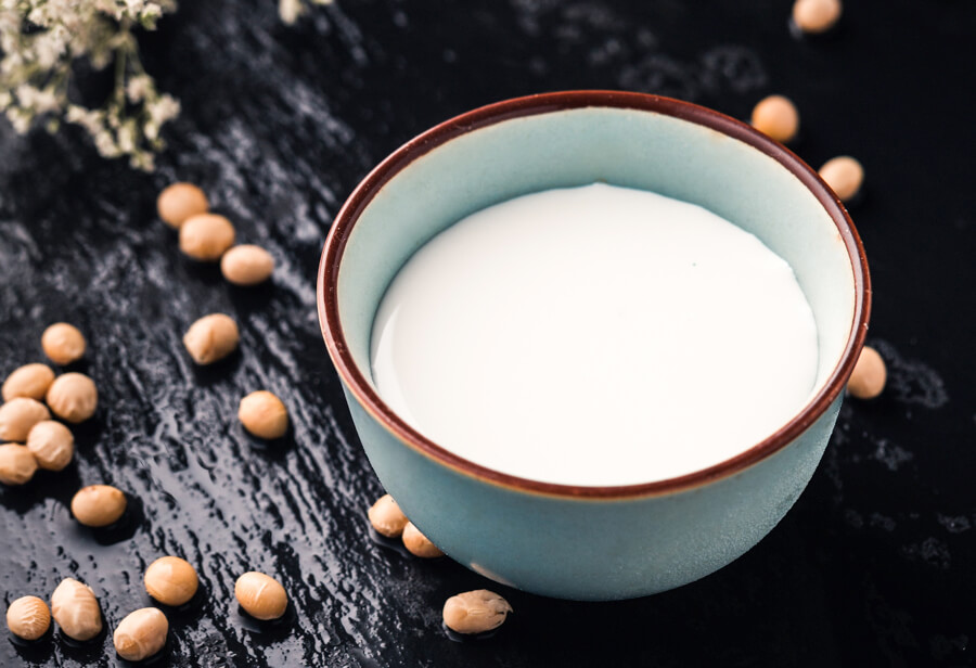 Sojamilch Darstellung mit Sojabohnen als Alternativernährung zu Kuhmilchprodukten bei Prostatavergrößerung